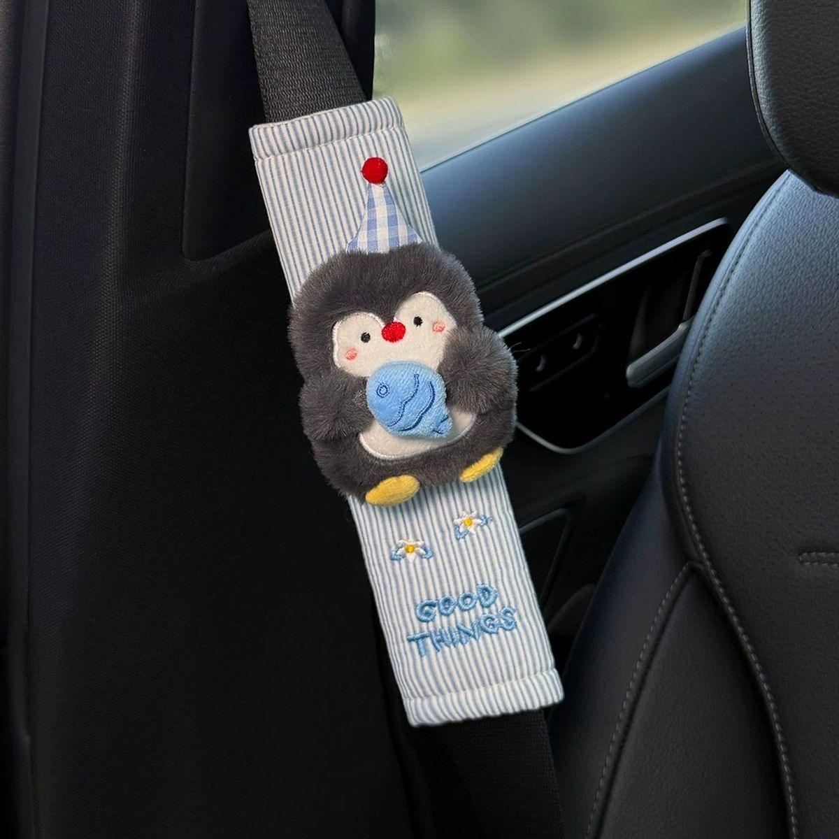 Party penguin seat belt cover with gingham hat detail.