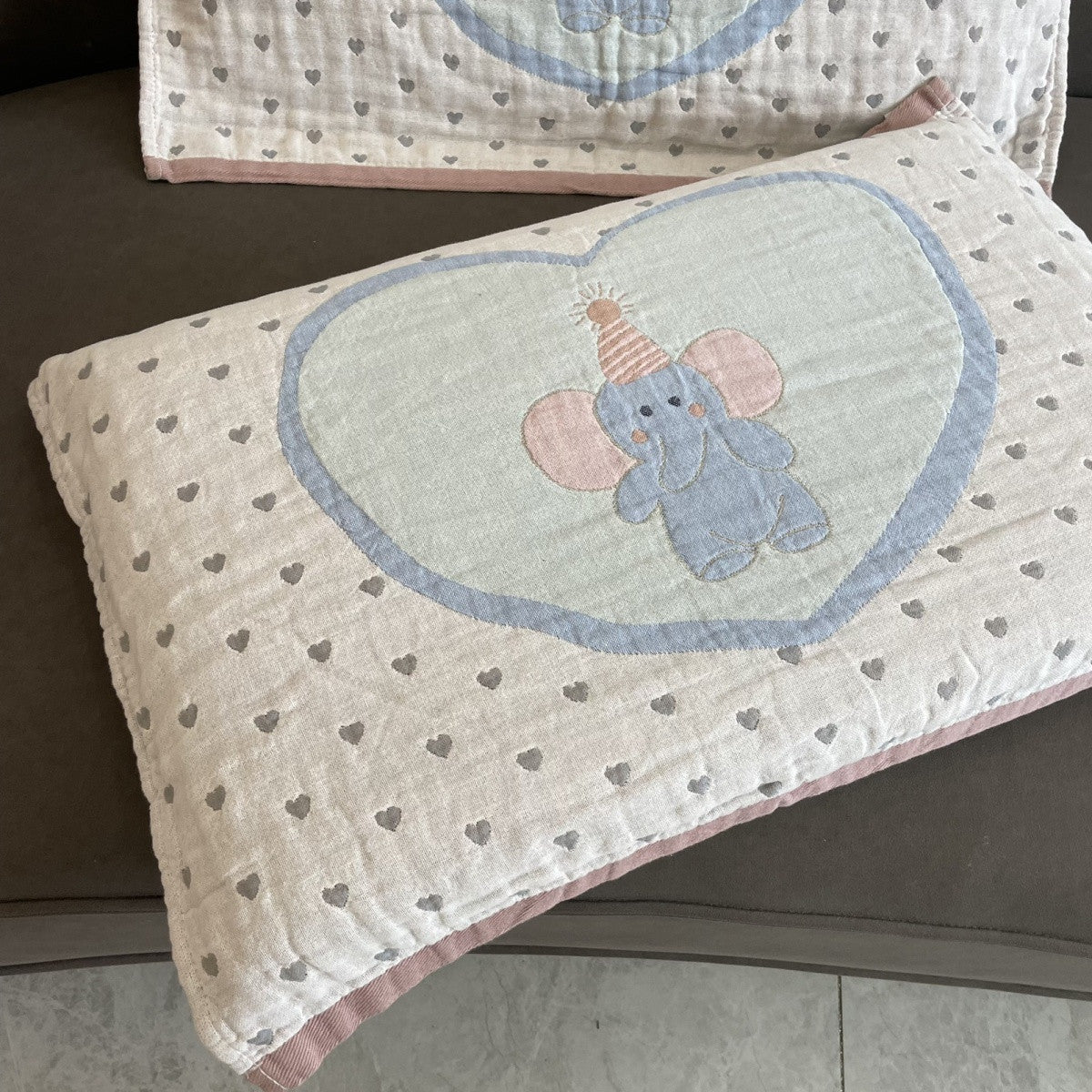 Close-up of embroidered heart elephant design on gauze cotton pillow towel.