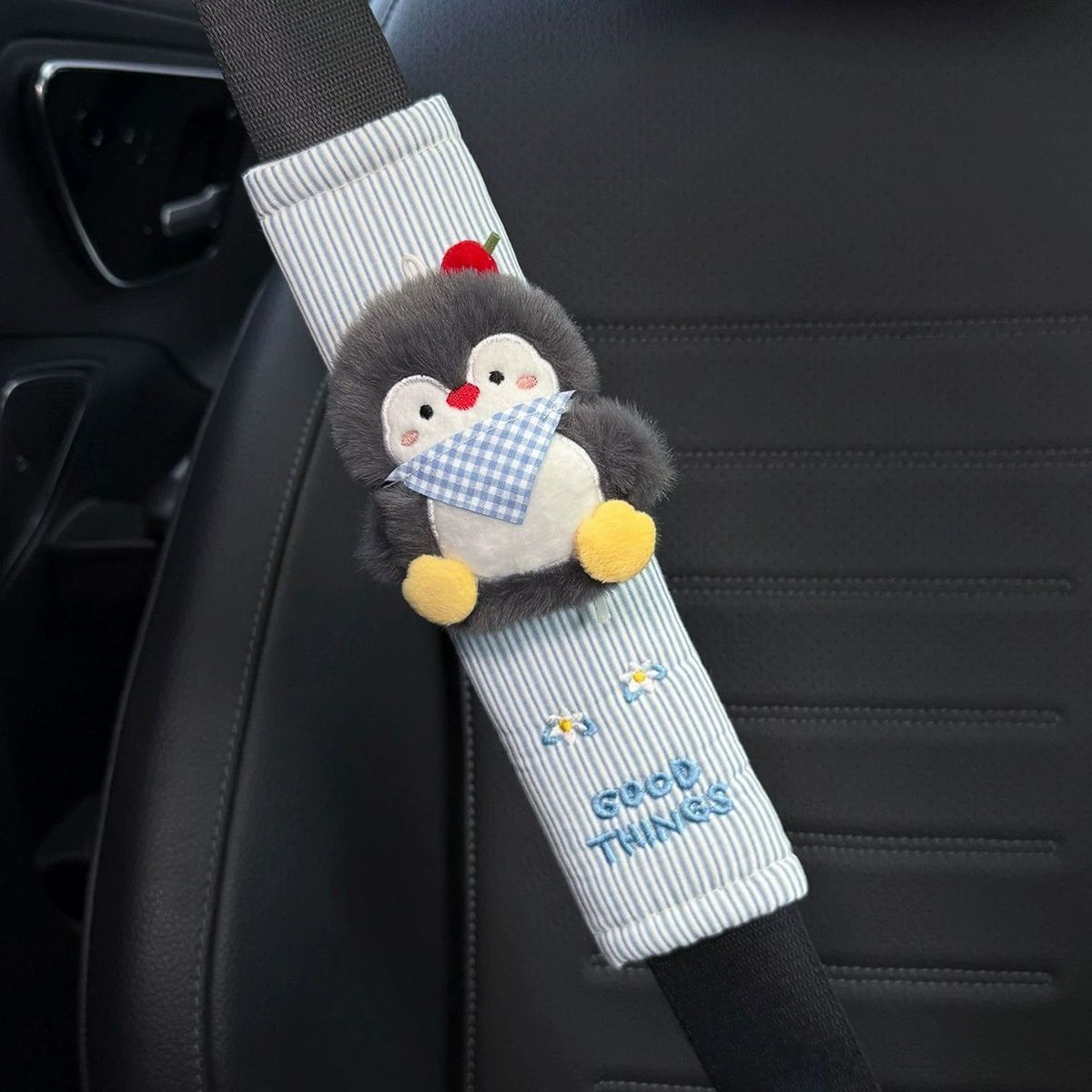 Close view of blue striped fabric around a plush party penguin seat belt cover.
