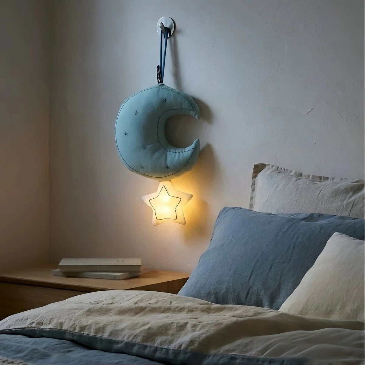 Blue hanging moon night light illuminated beside bed