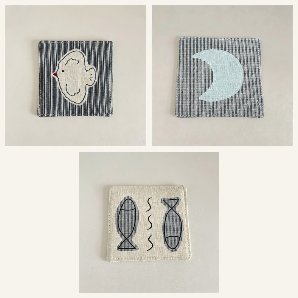 Cotton-linen fabric coaster set showing bird and moon and fish designs.