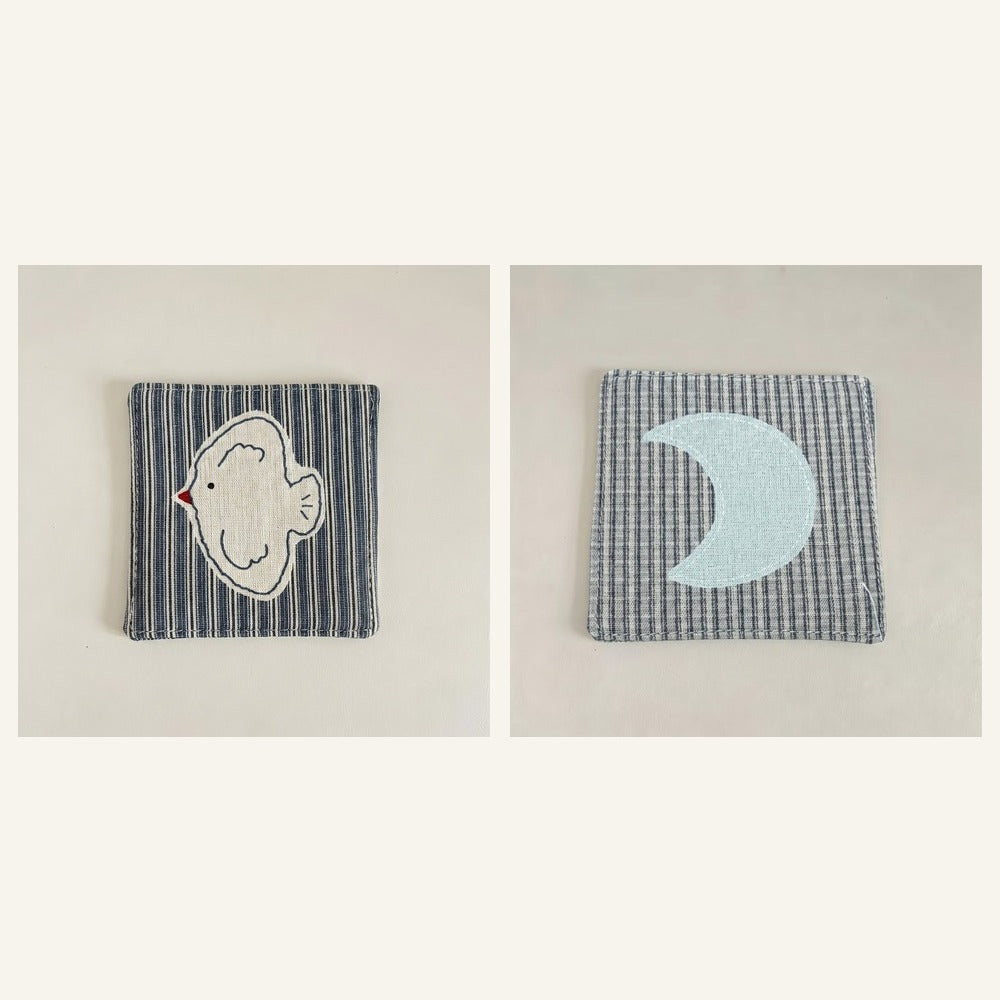 Cotton-linen fabric coaster set showing bird and moon designs.