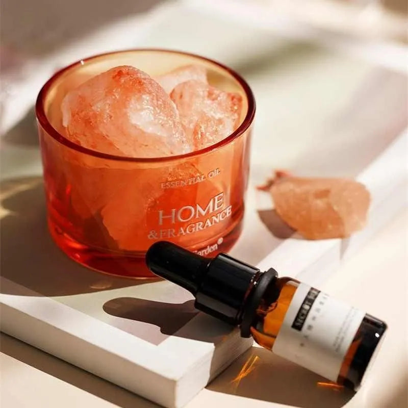 Orange Crystal diffuser bowl with crystal stones beside an essential oil bottle
