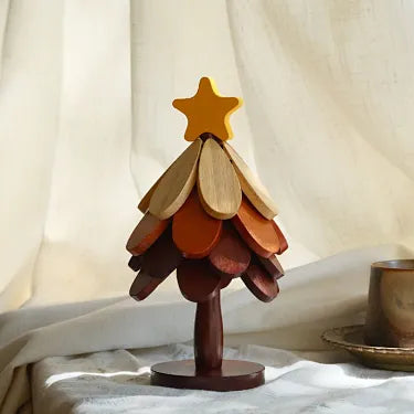 Star topper four layer wooden Christmas tree trivet on a table