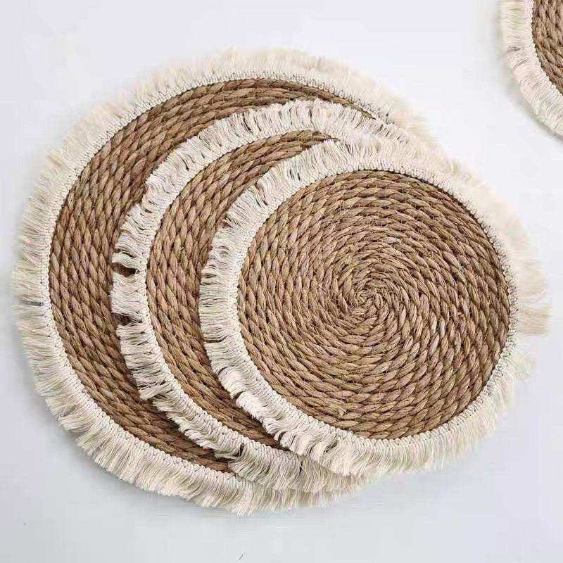 Three sizes of round woven straw mats with cream fringe