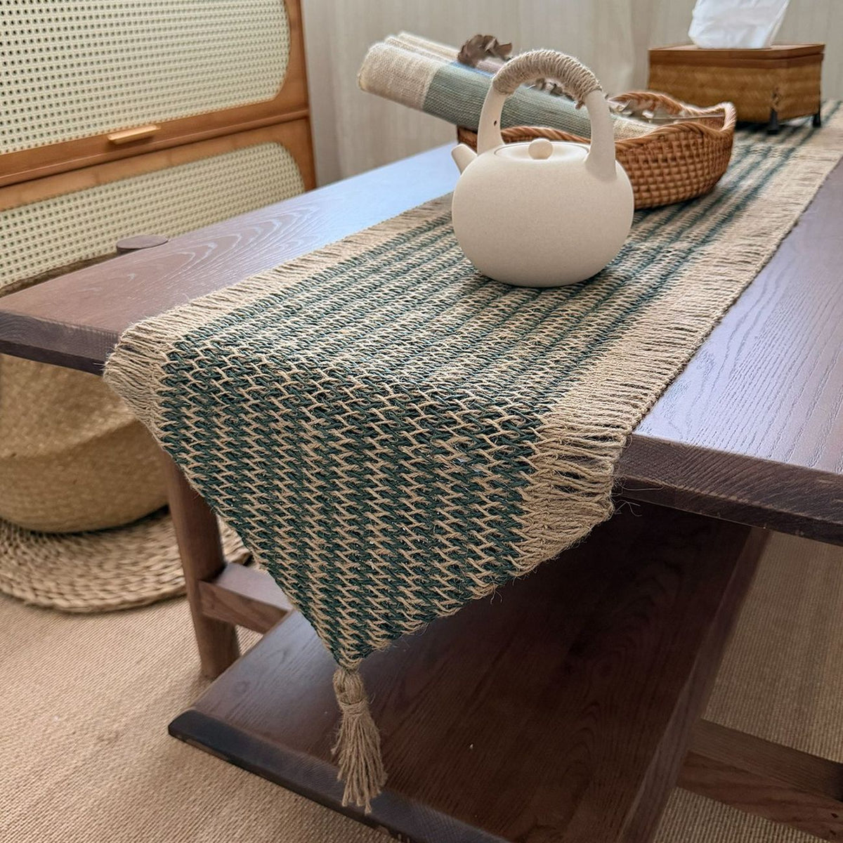 Natural and forest green jute-look woven table runner displayed across a dining table
